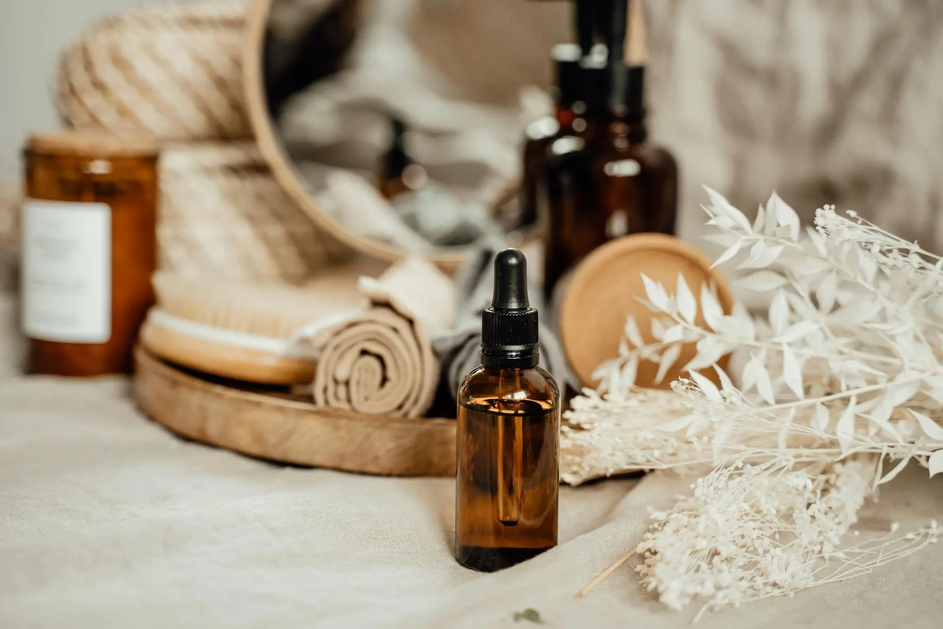 Handcrafted essential oils for everyday calm Amber dropper bottle with spa essentials and natural décor.