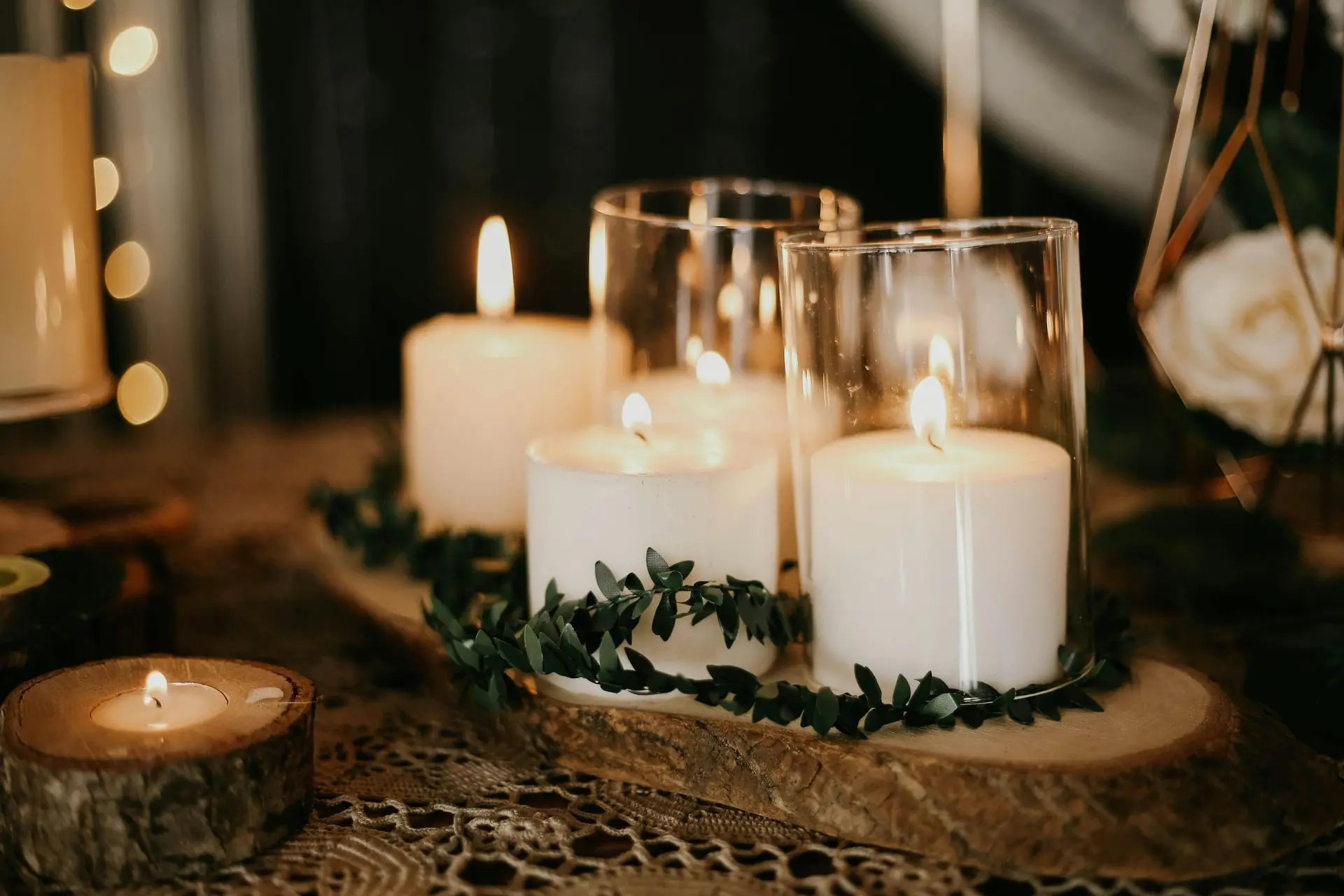 Aromatherapy candles to soothe your senses Lit soy candle beside dried flowers and soft textiles.
